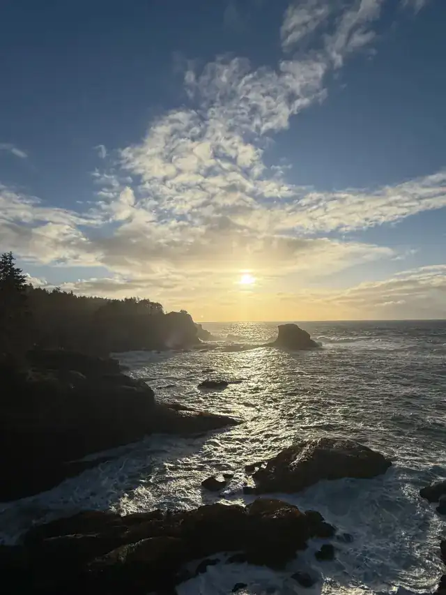 Sun breaking over dark coastal rocks on the Pacific coast