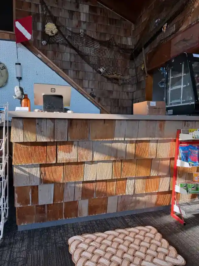 The cedar-shingled office counter at Curley's with tackle on the shelf behind it