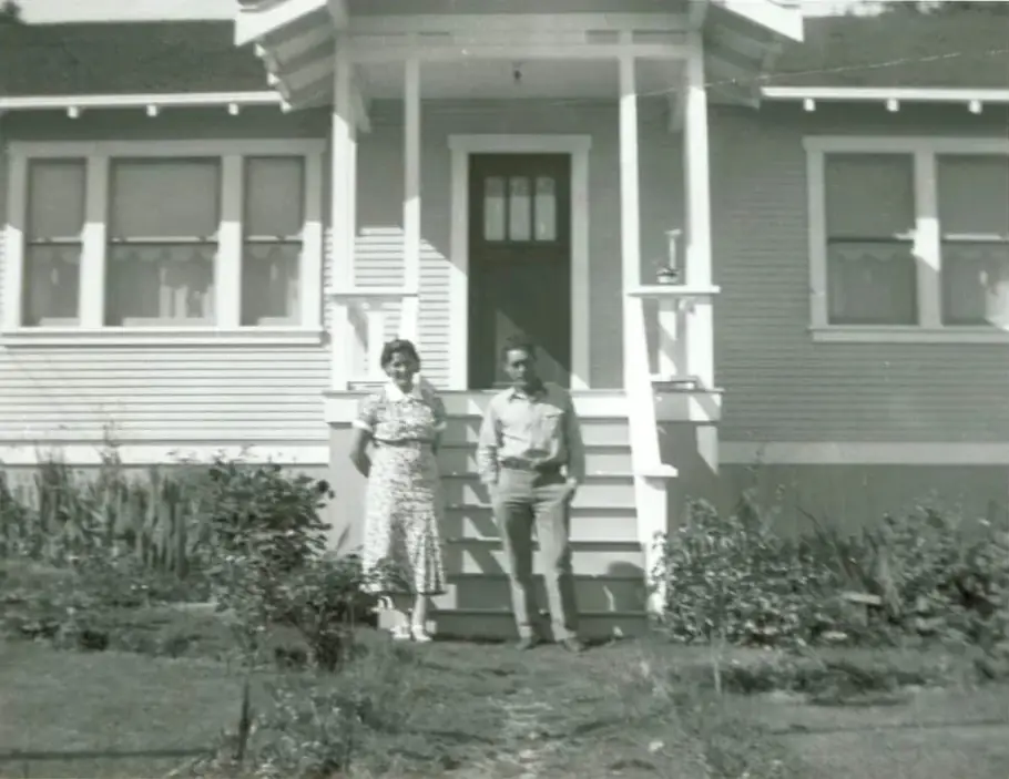 The Couvelier couple standing in front of the original house, black and white